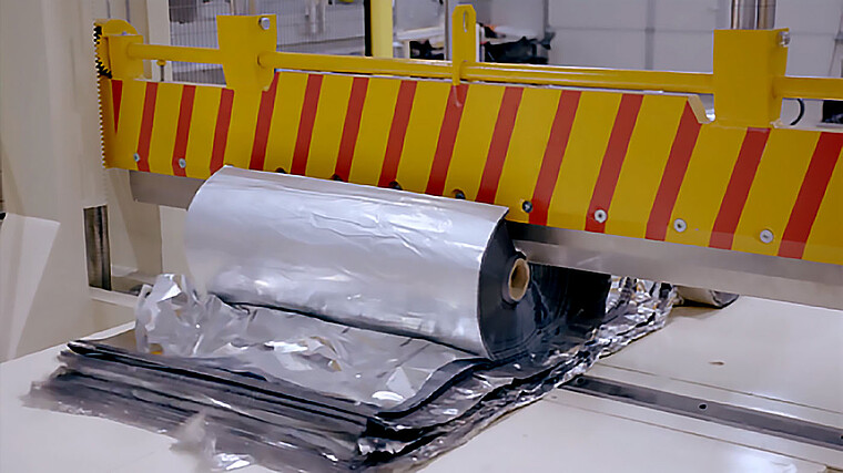 Eine große Rolle PET-Träger wird von einer Schneidemaschine aufgeschnitten.